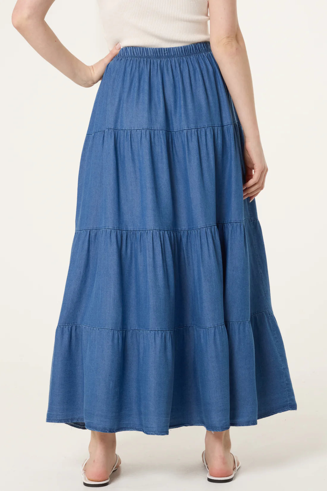 Blue tiered skirt worn by a person on a white background