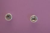 Pair of round earrings with grey gemstones on a purple background