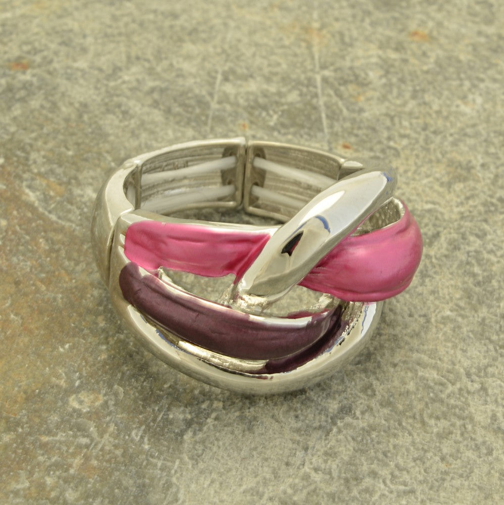 Silver ring with pink and purple accents on a textured surface