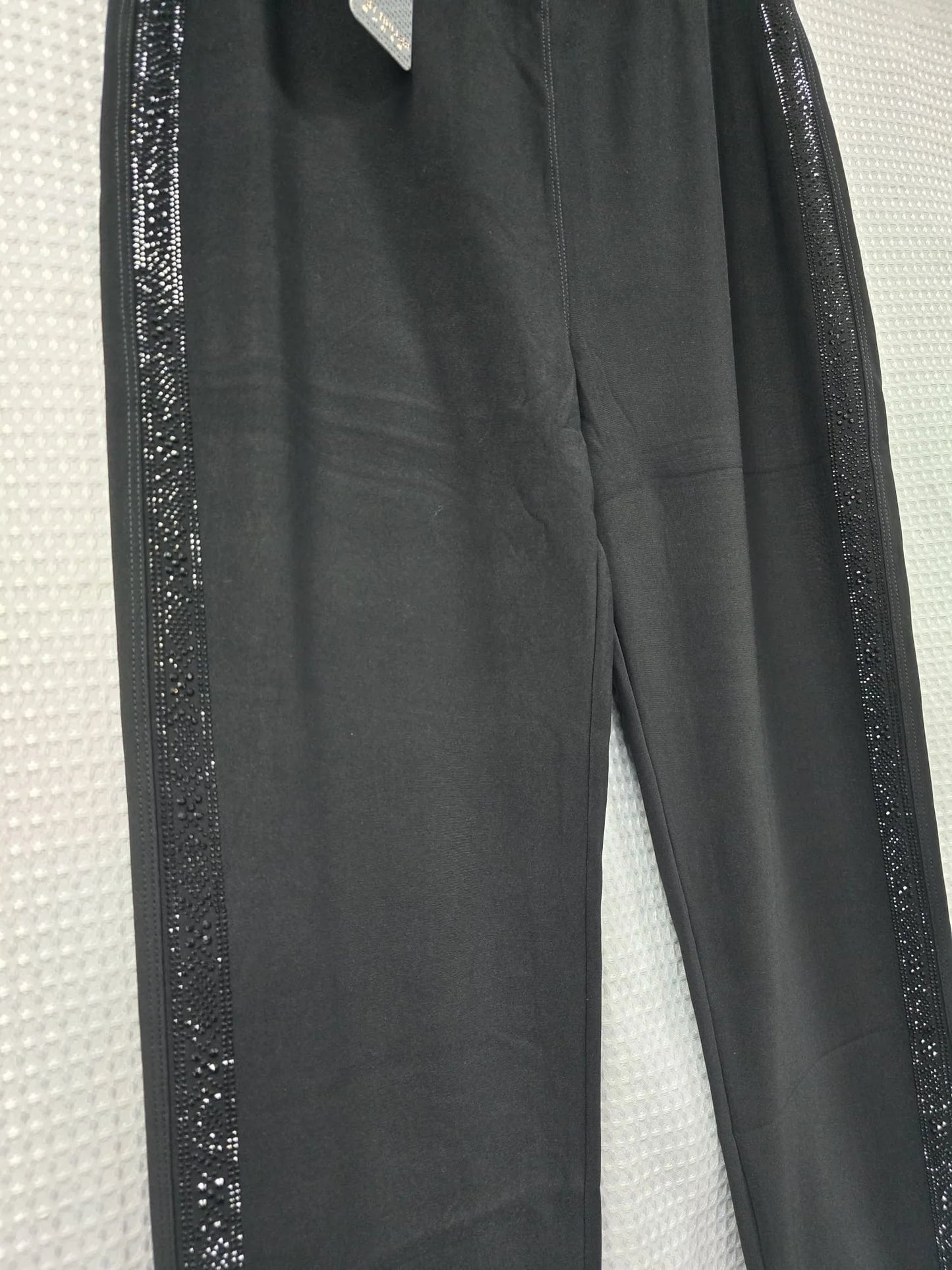 Black trousers with black diamantes down the sides on a white background