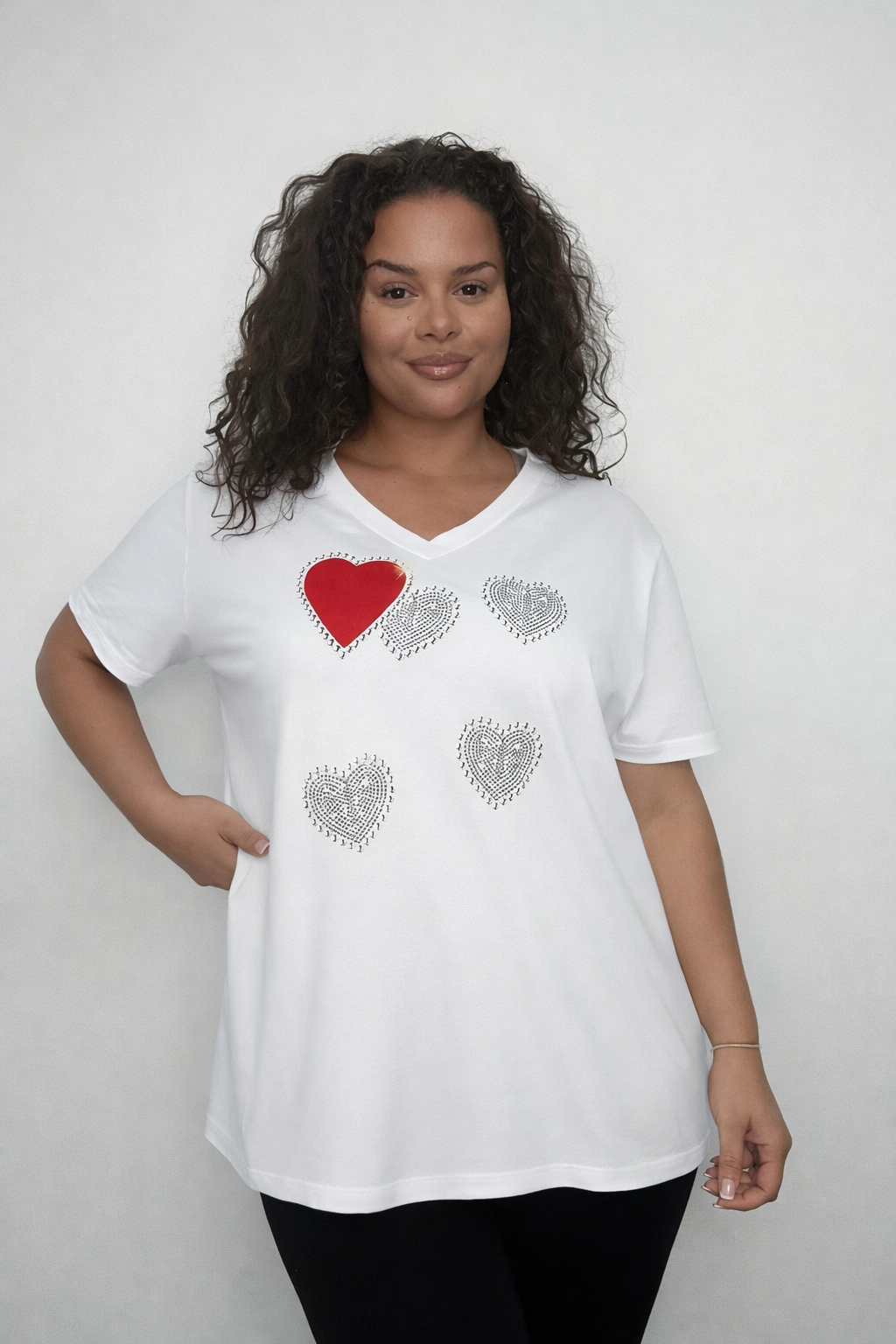 Woman wearing a white Plus Size Heart V-Neck T-Shirt on a plain background