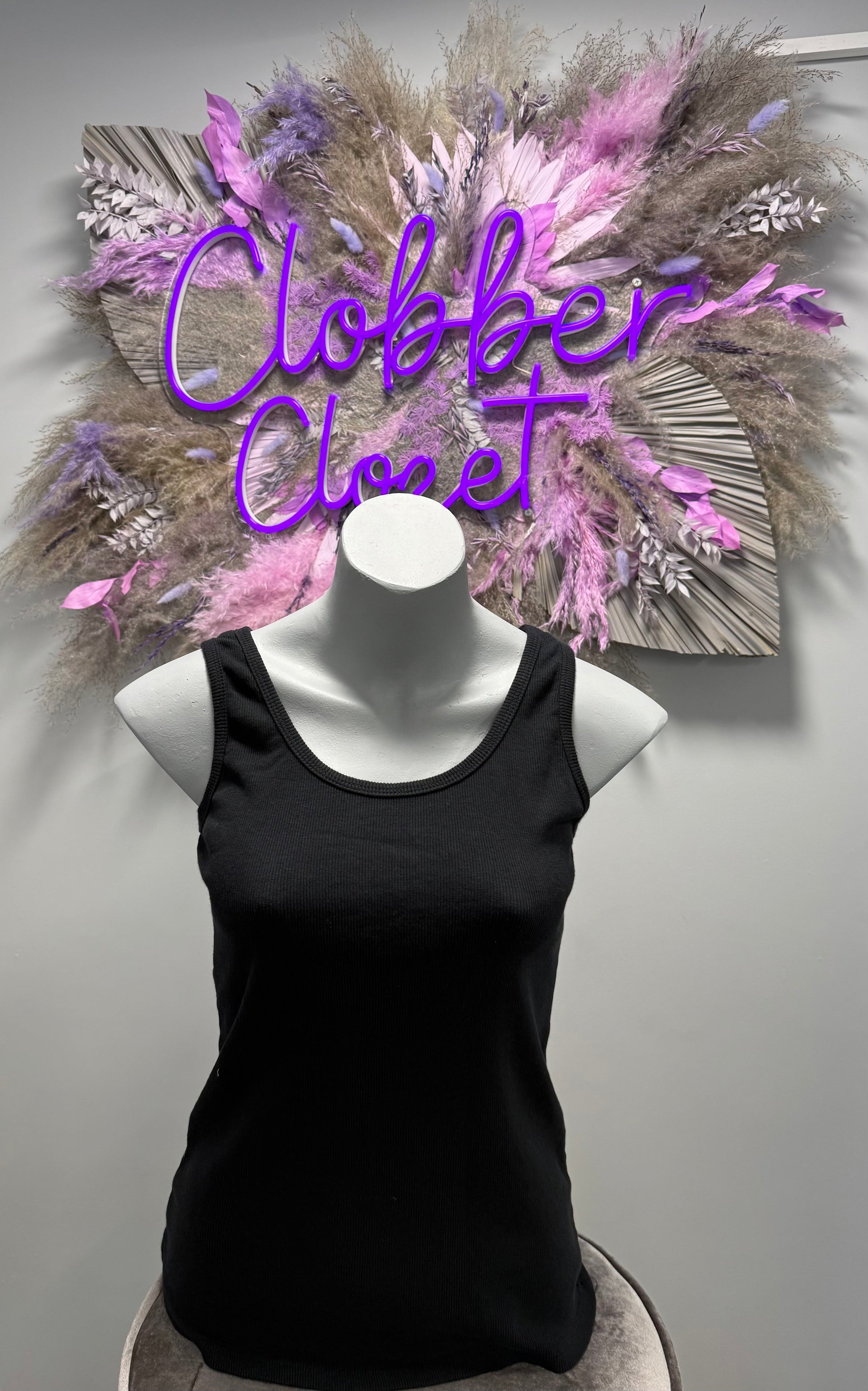A mannequin wearing a black cotton ribbed vest