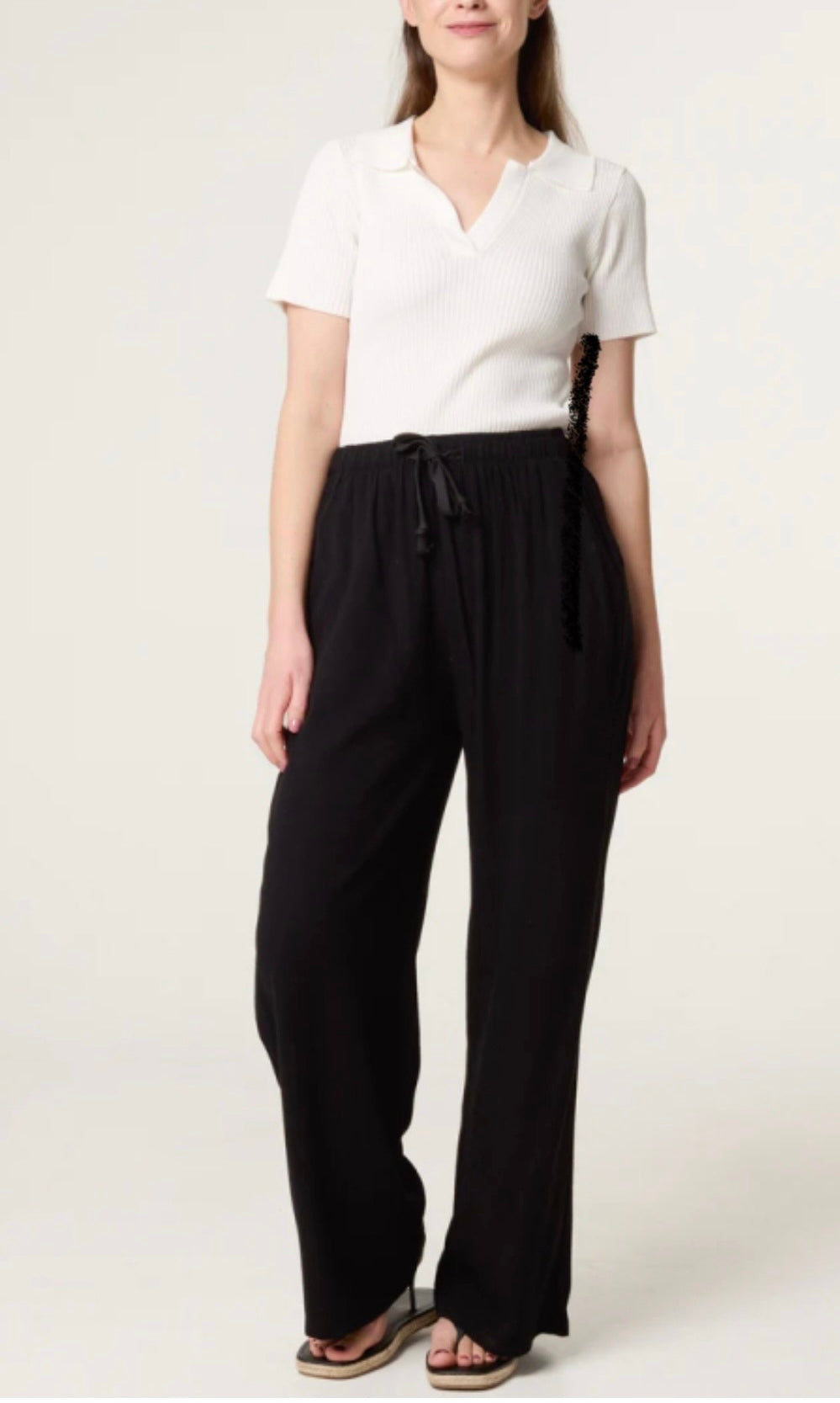 Woman wearing a white top and Black Linen Blend Drawstring Pocket Trousers on a white background