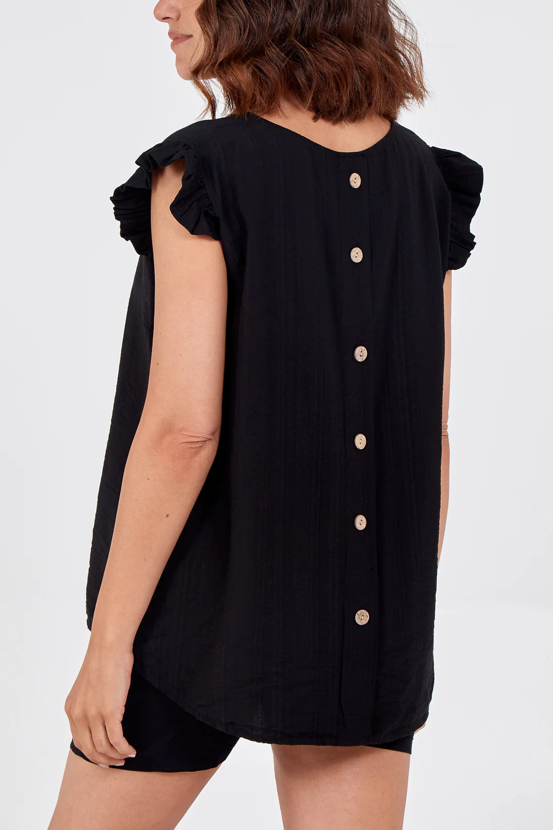 Black sleeveless top with button details on a white background