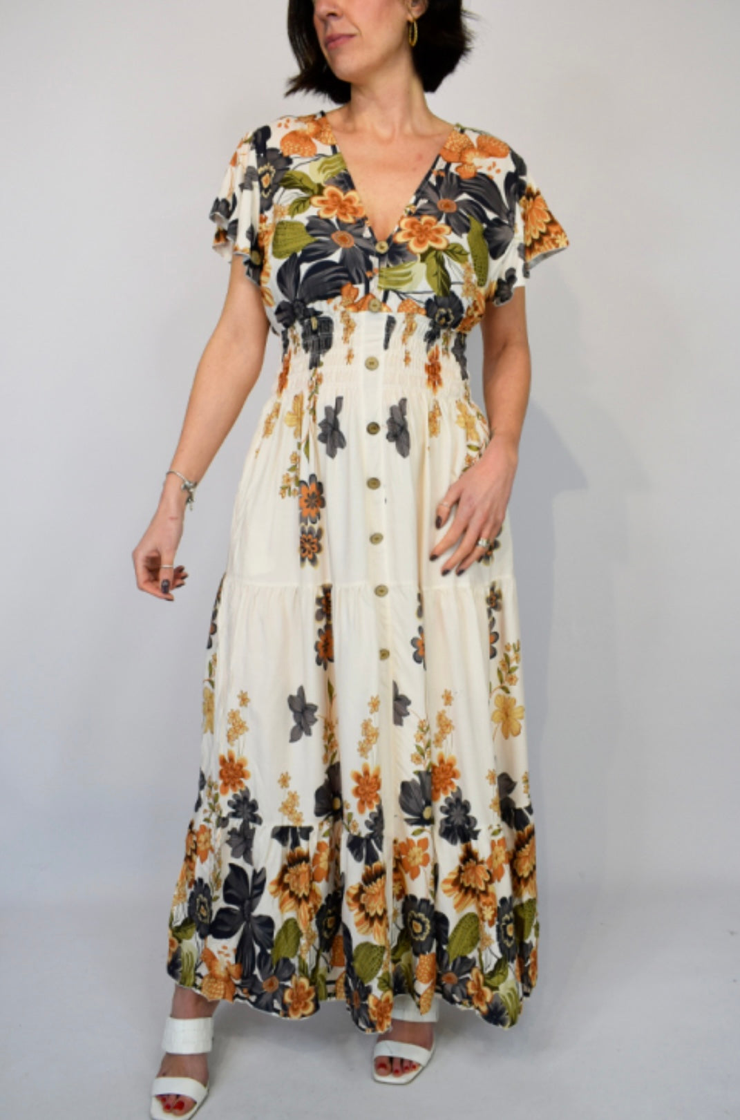 Woman wearing a Black and Orange Bold Flower Border Button Maxi Dress against a plain background