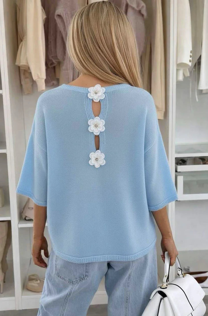 Back view Woman wearing Blue Floral Appliqué Lightweight Open-Knit Fabric Knitted Jumper in front of open wardrobe 