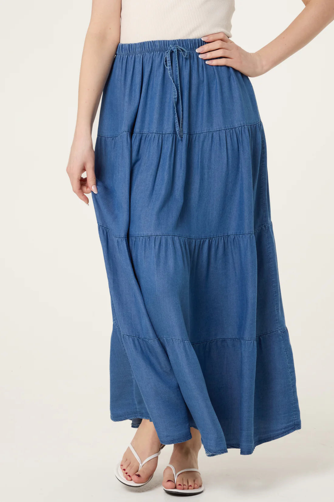 Blue tiered skirt worn by a person on a white background