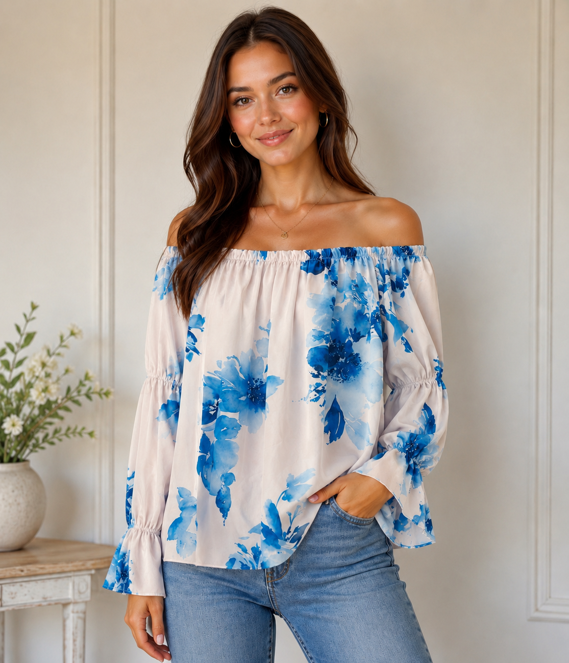 Woman wearing a floral off-shoulder top and jeans indoors.