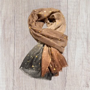 Gradient scarf transitioning from green to brown on a wooden surface