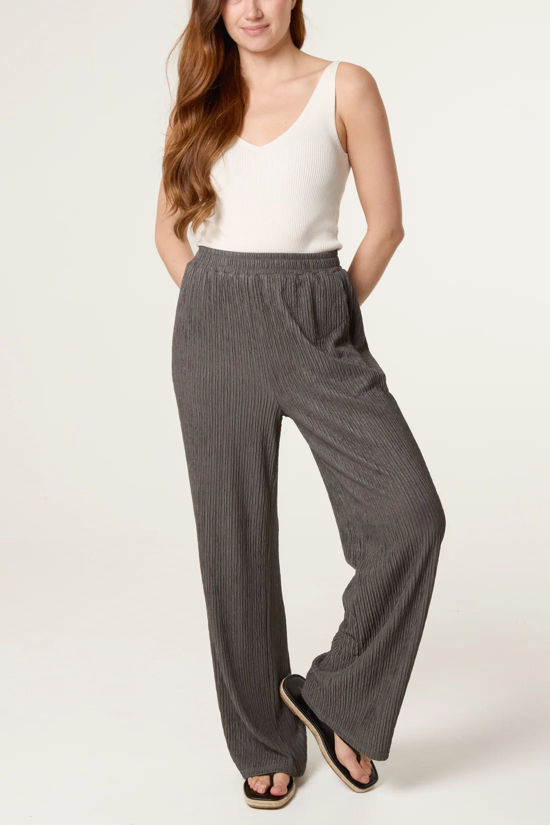 Woman wearing Dark Khaki Elastic Waist Crinkle Trousers and a white top on a white background