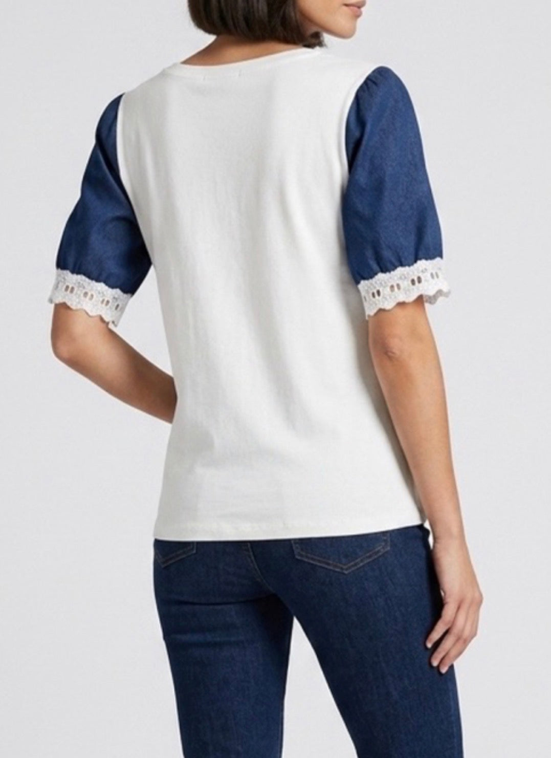 Back view of White top with blue sleeves and jeans on a white background