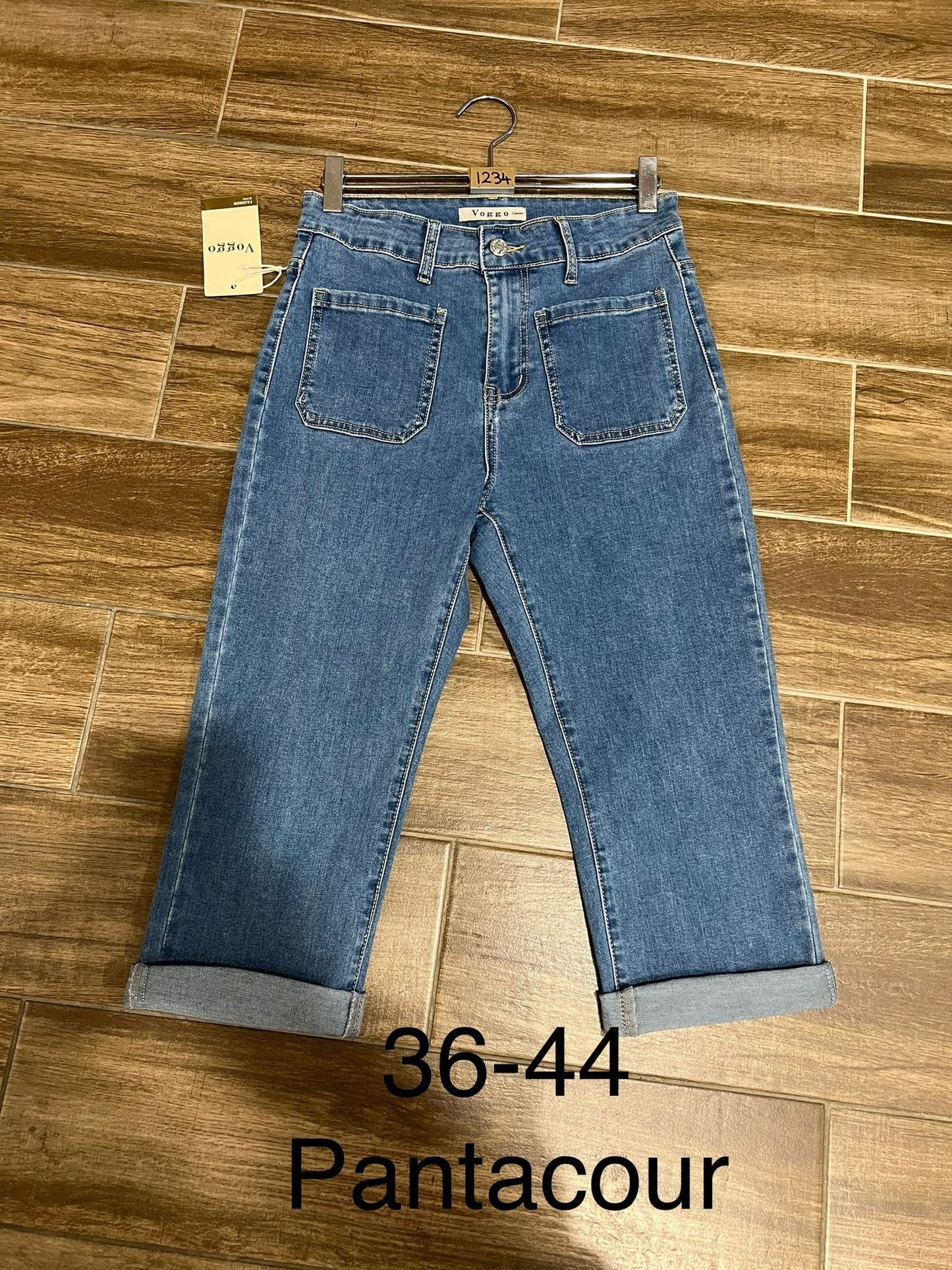 Blue jeans on a hanger with a Pantacour tag against a wooden floor background