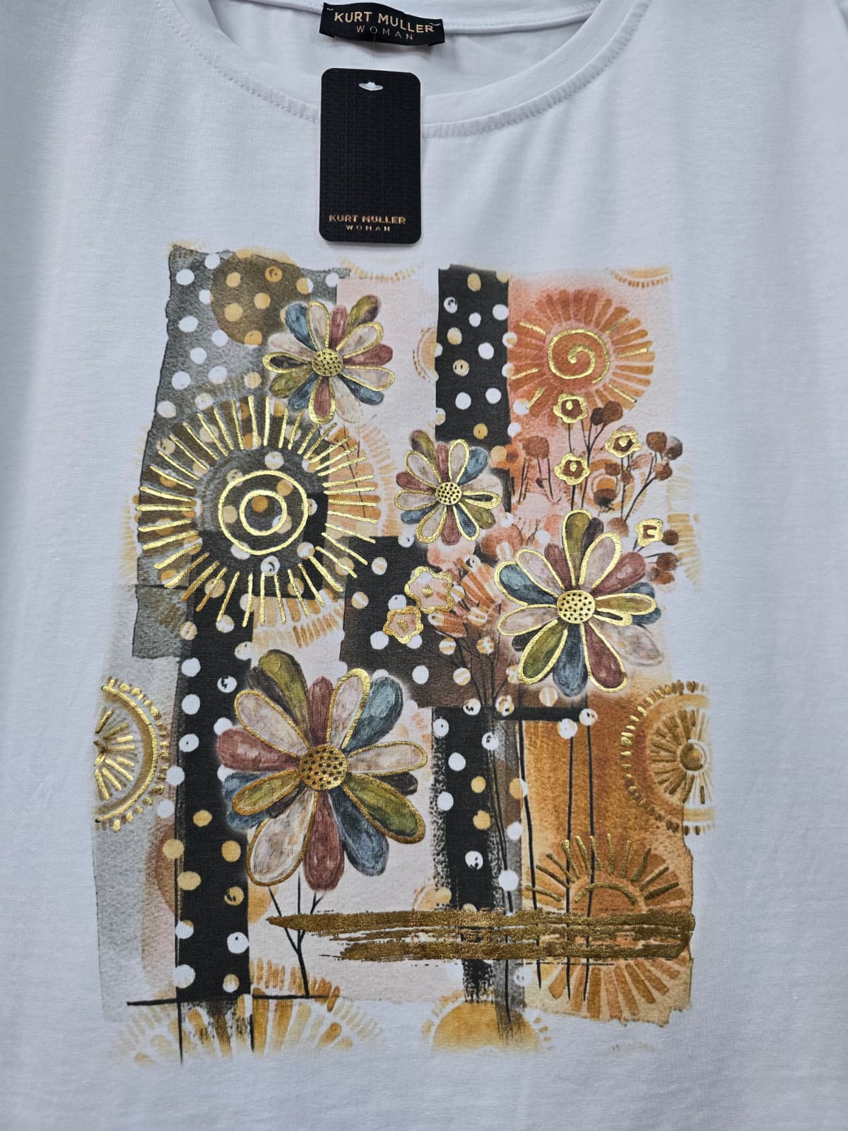 White t-shirt with decorative floral and abstract designs on a plain background