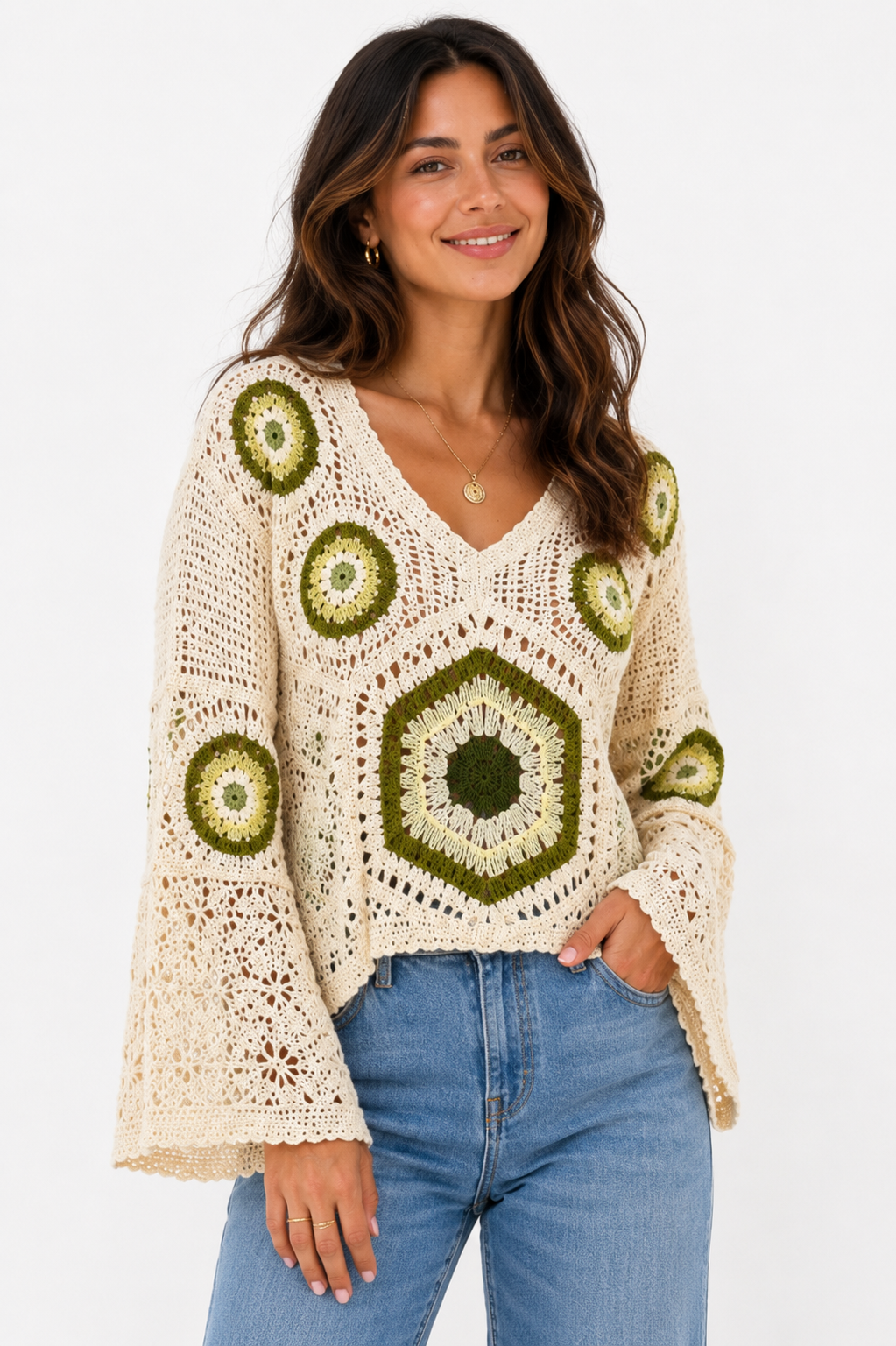 Woman wearing a crochet sweater with green hexagonal patterns on a white background