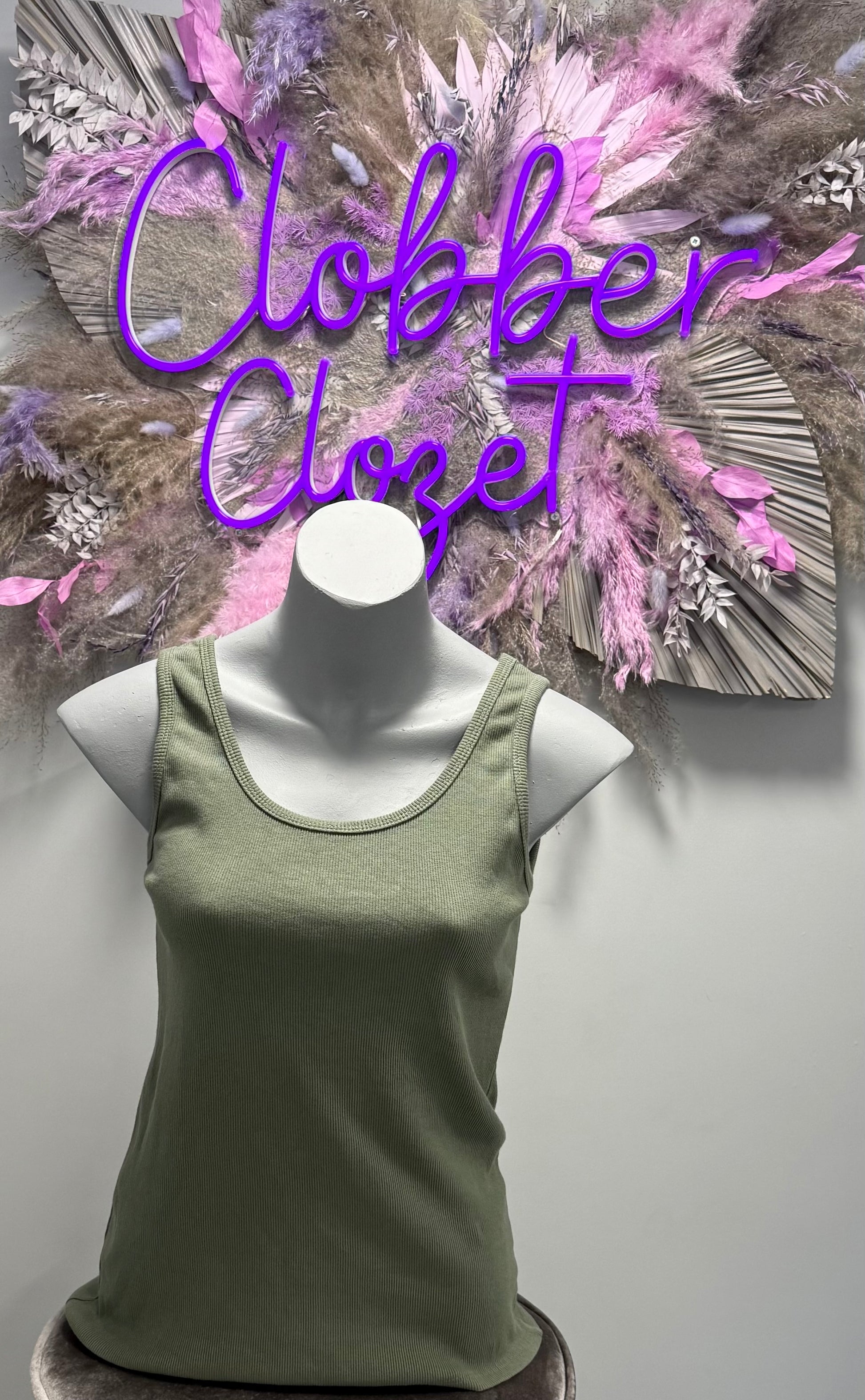 Green Cotton Ribbed Vest Top on a mannequin against a decorative background.