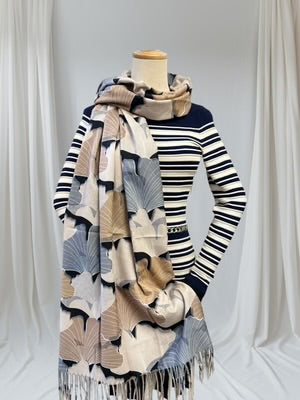 Mannequin wearing a striped sweater with a patterned scarf against a white background