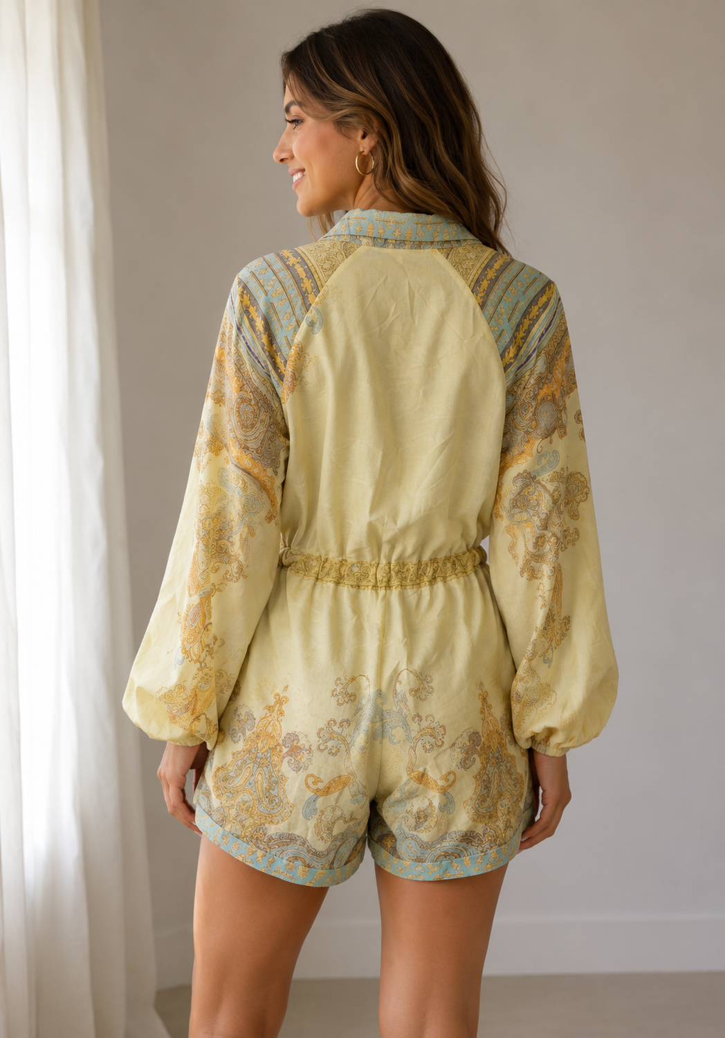 Back View of Woman wearing a patterned romper in a neutral setting