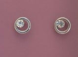 Pair of silver earrings with clear gemstones on a pink background