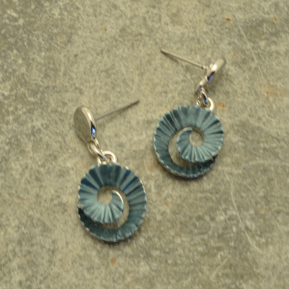 Miss Milly Green Ammonite Earrings on a textured surface