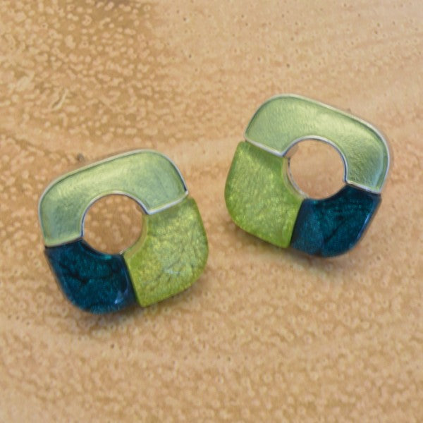 Pair of green and blue earrings on a beige background