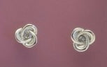 Silver earrings on a purple background