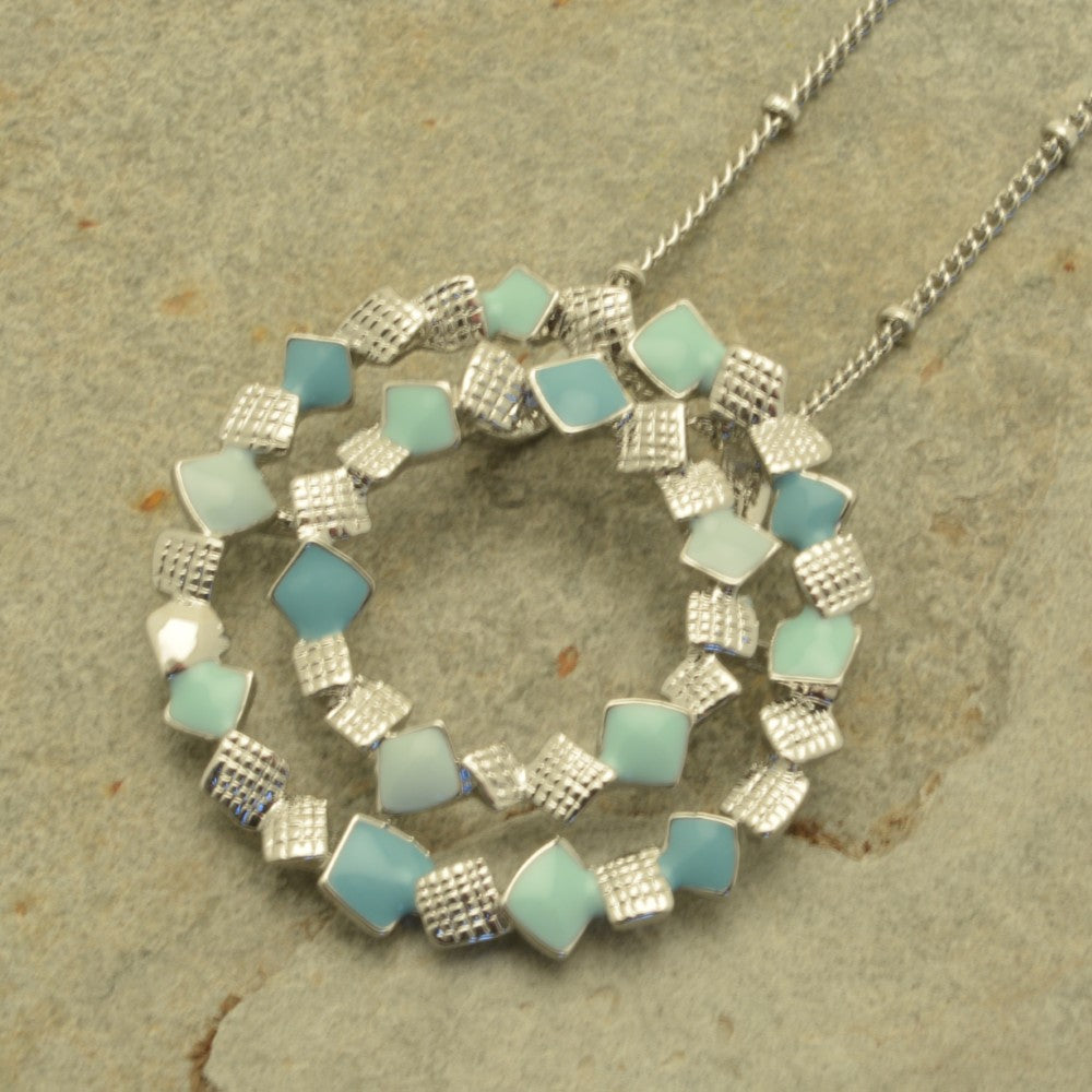 Miss Milly Mint Green Confetti Necklace on a textured surface
