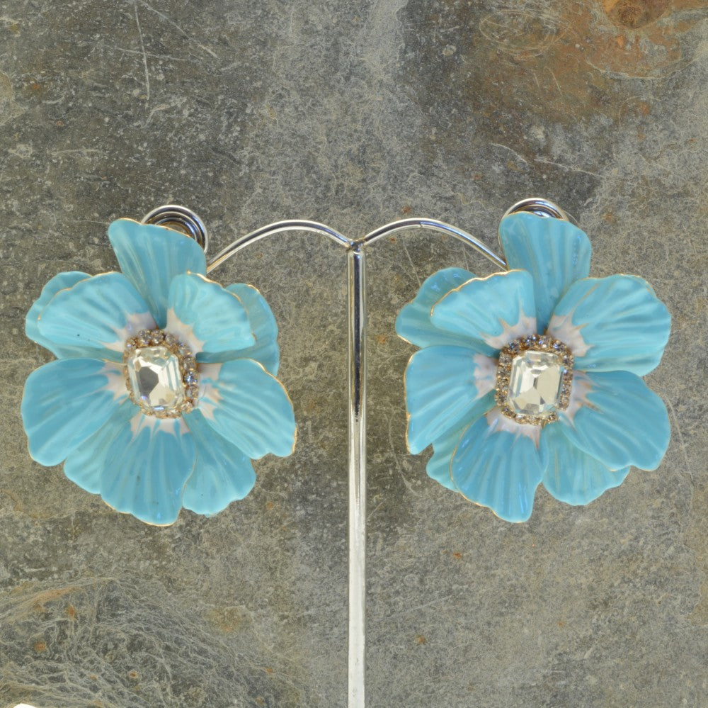 Miss Milly Turquoise Flower Statement Earrings On display stand with textured background 