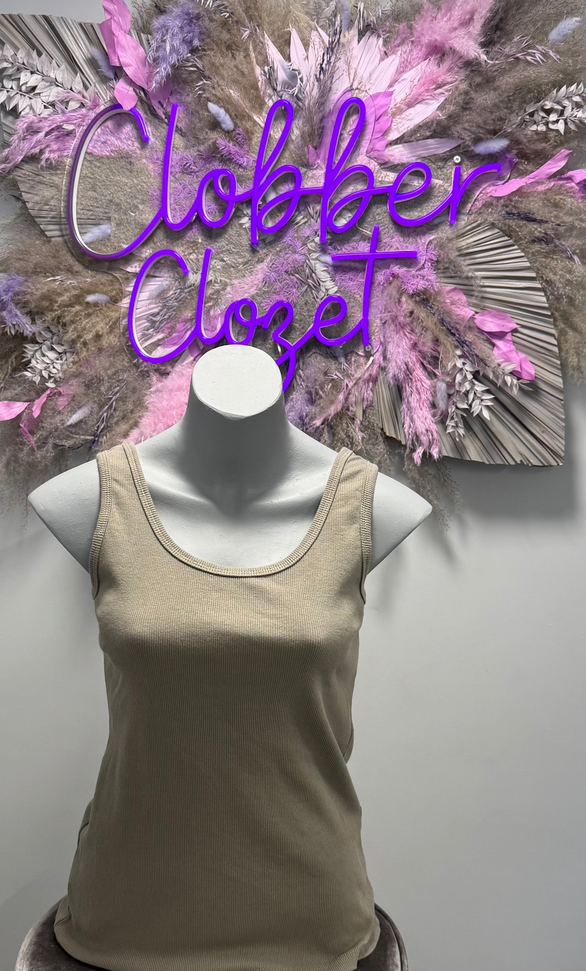 Mannequin wearing a mocha Cotton Ribbed Vest Top with a decorative background.