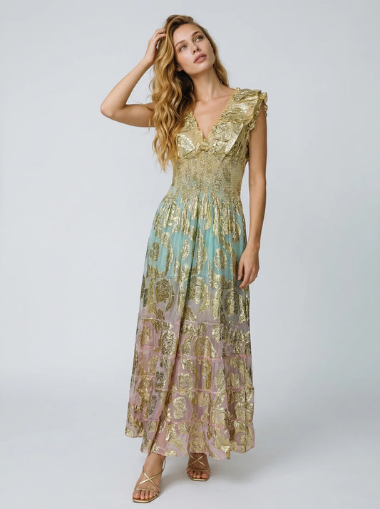 Woman wearing a gold and blue patterned dress on a white background