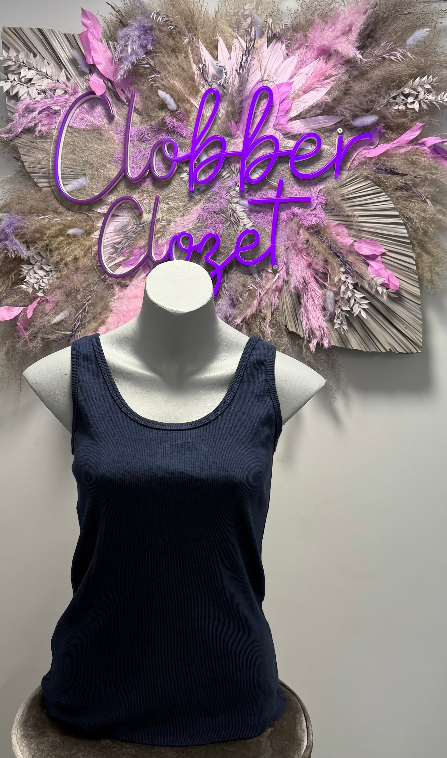 Navy Cotton Ribbed Vest Top on a mannequin with decorative background