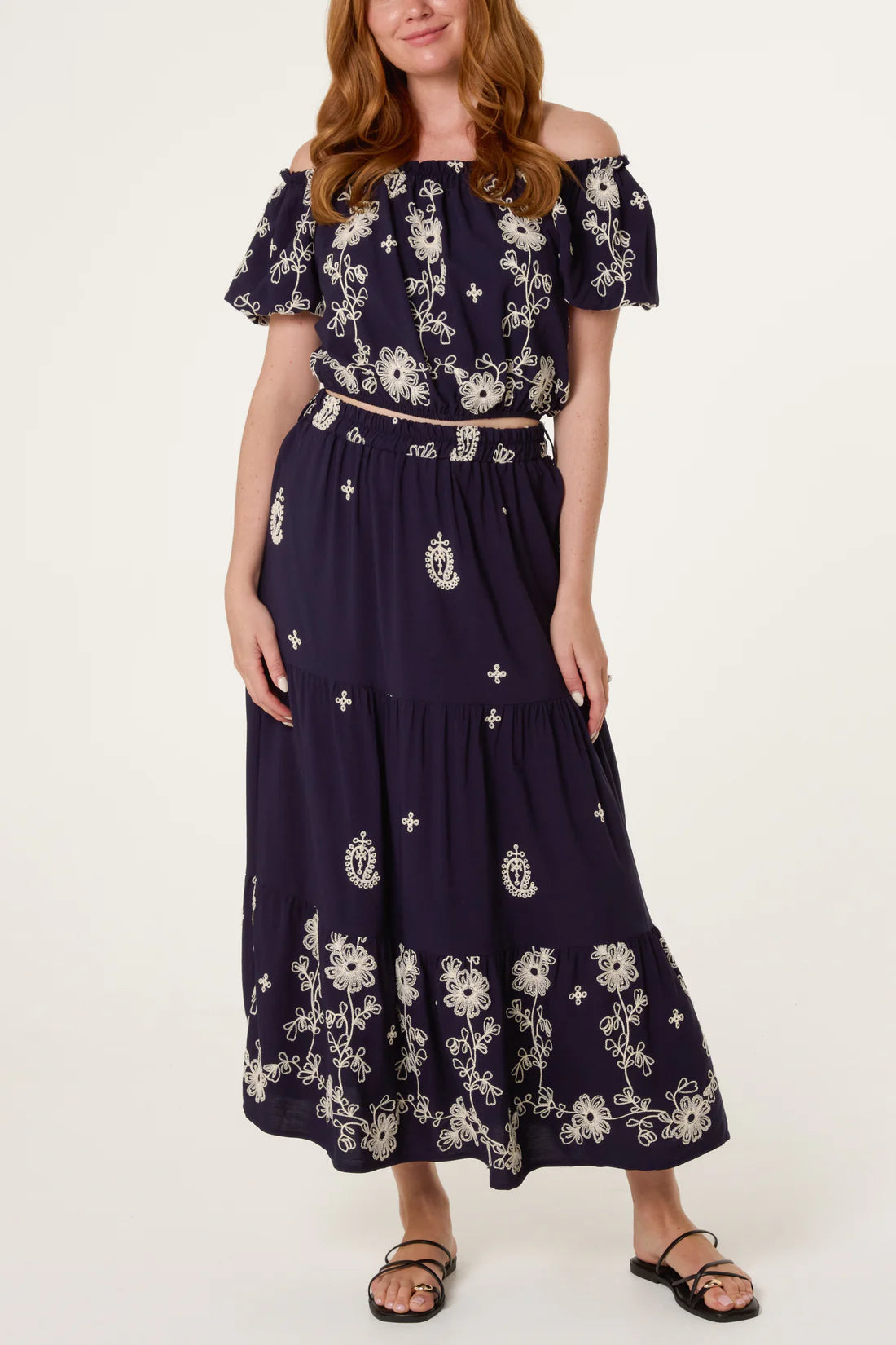 Woman wearing a Navy Embroidery Bardot Puff Top & Skirt Set on a white background