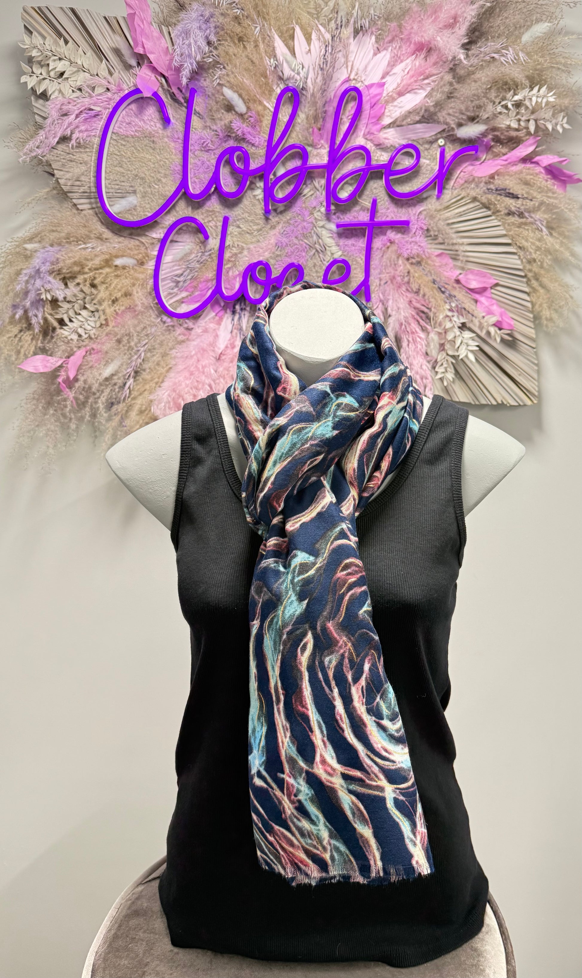 Black sleeveless top with a colorful scarf on a mannequin against a decorative floral background with 'Clobber Closet' text.