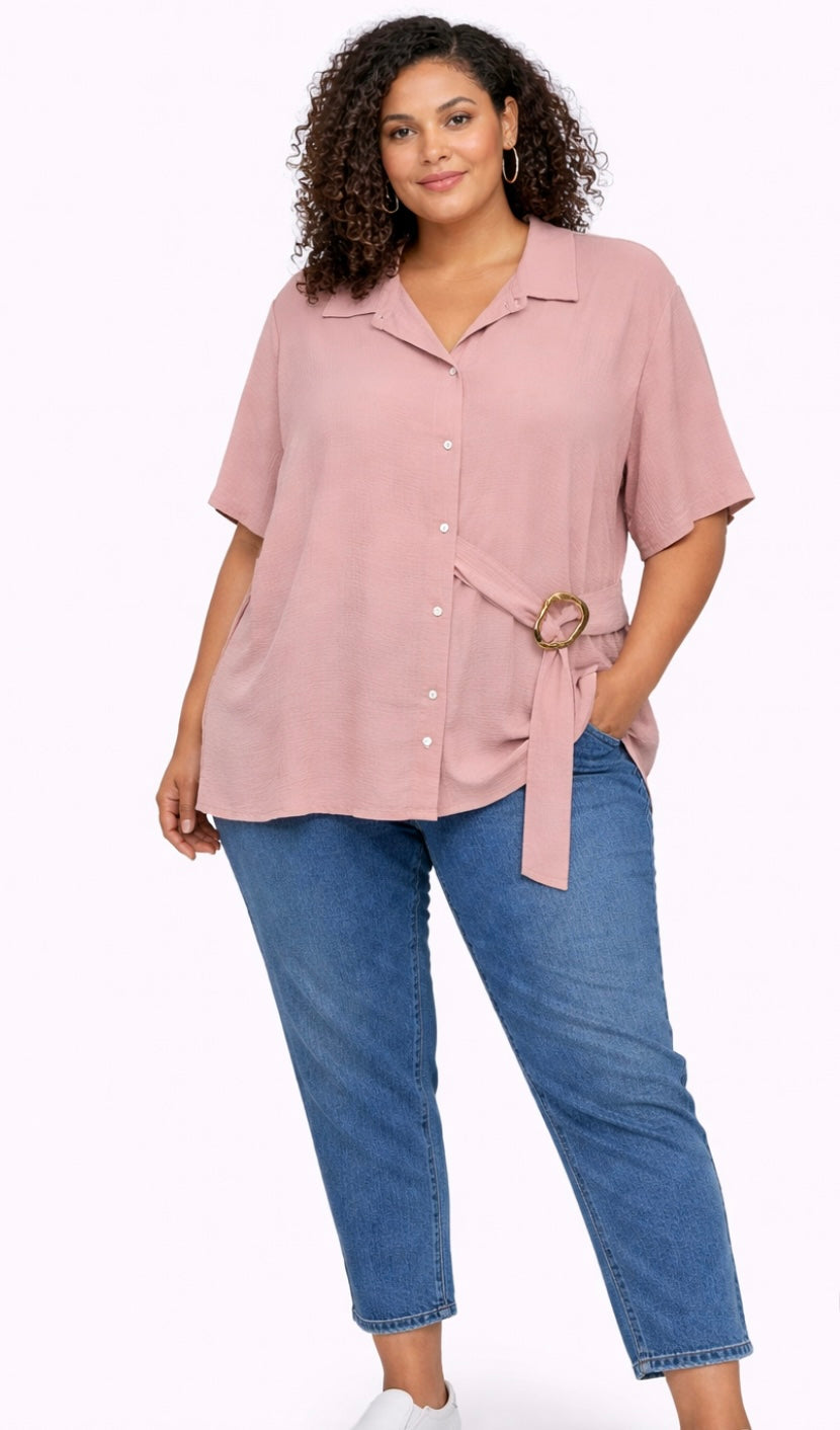 Woman wearing a pink Plus Size Textured Belted Button-Through Shirt Top and blue jeans on a white background