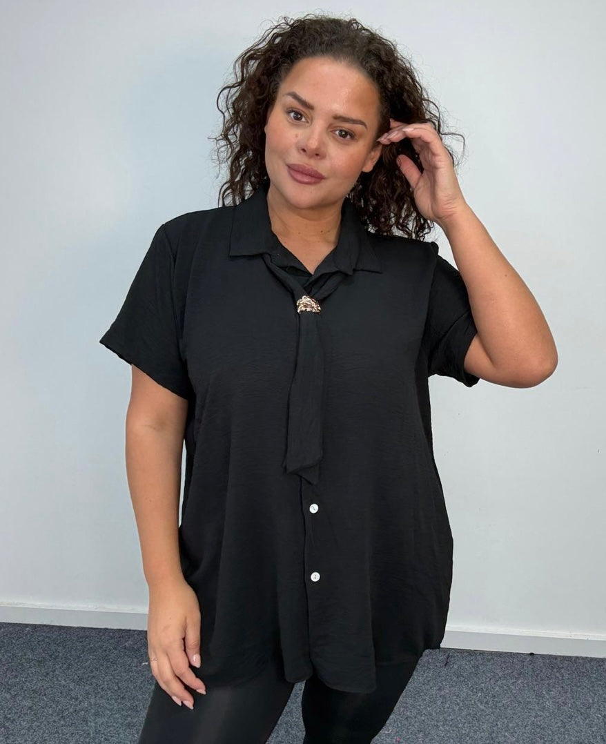 Woman wearing a Plus Size Black Tie Neck Button Front Blouse with a collar against a plain background