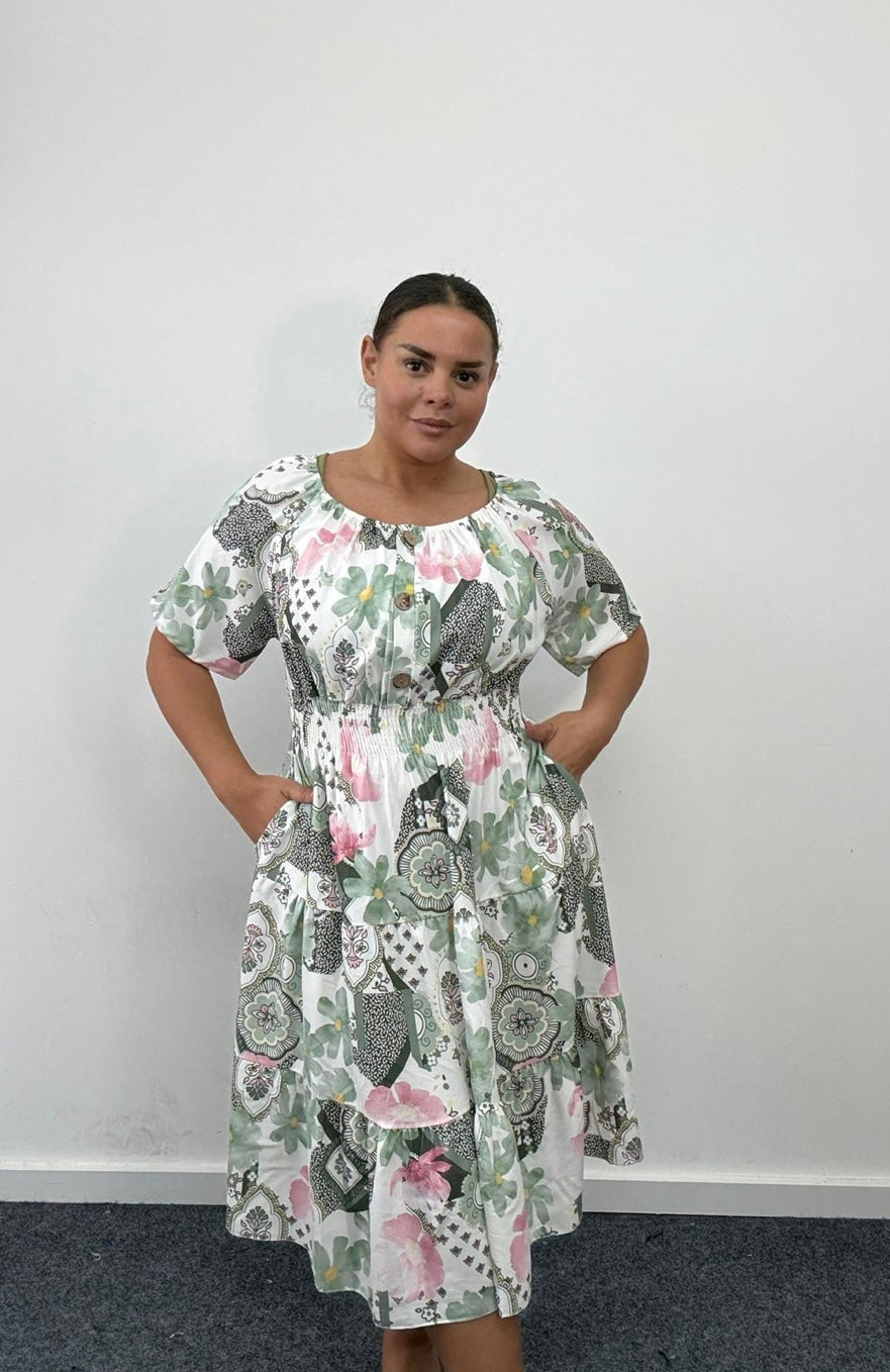 Woman wearing a Plus Size Khaki Floral Print Tiered Shirred Waist Midi Dress with Pockets against a plain background