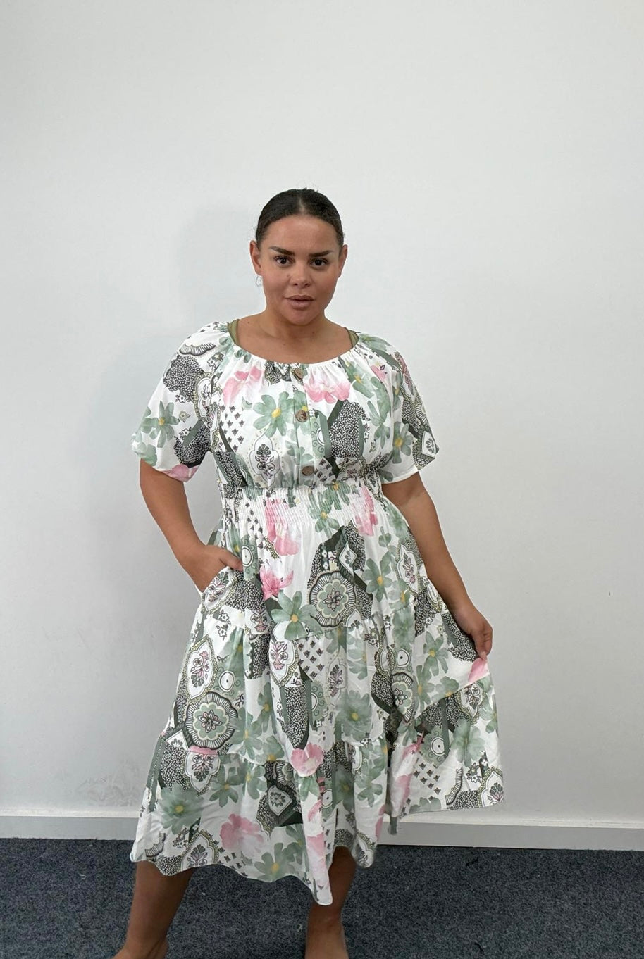 Woman wearing a Plus Size Khaki Floral Print Tiered Shirred Waist Midi Dress with Pockets against a plain background