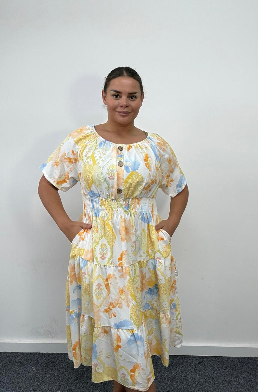 Woman wearing a Plus Size Yellow Floral Print Tiered Shirred Waist Midi Dress with Pockets against a plain background