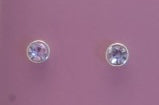 Pair of silver stud earrings with purple violet gemstones on a purple background