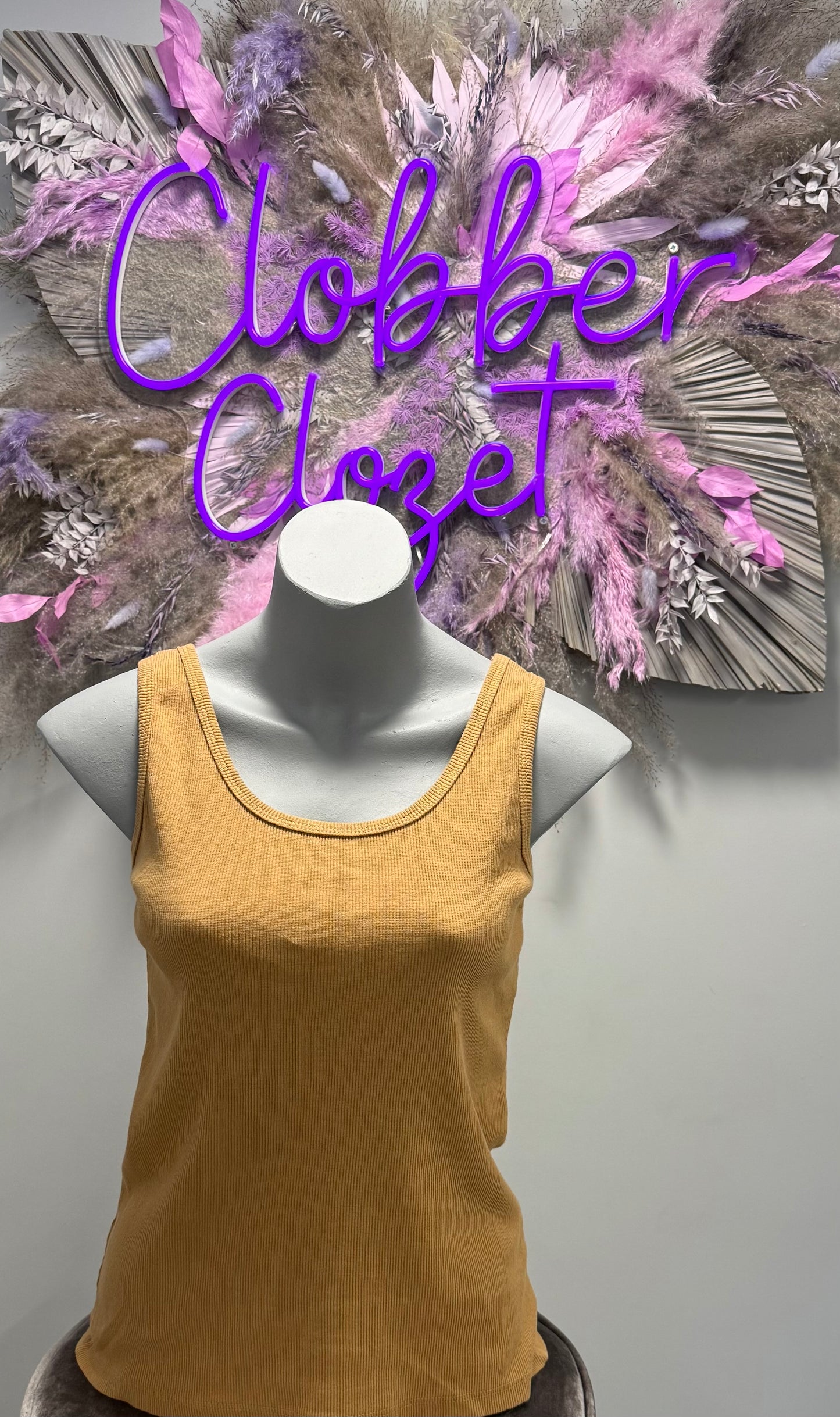 Sand Cotton Ribbed Vest Top on a mannequin with decorative background.