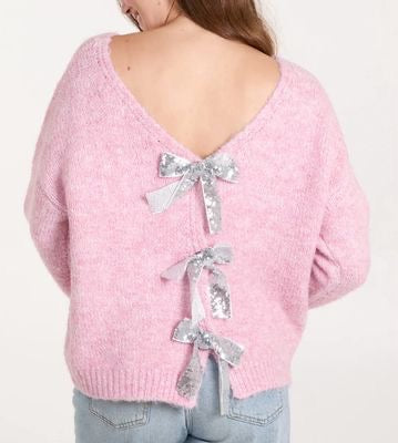 Pink sweater with silver bow details on a white background