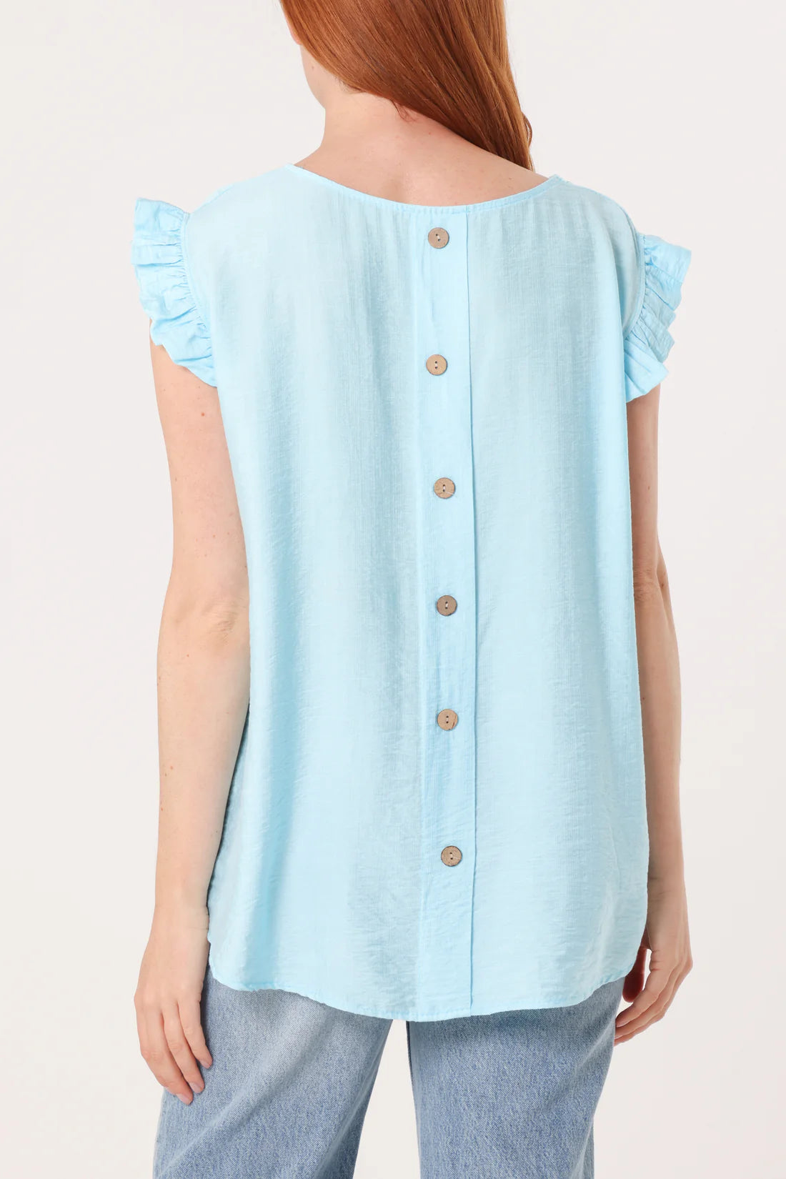Light blue blouse with ruffled sleeves worn by a person on a plain background
