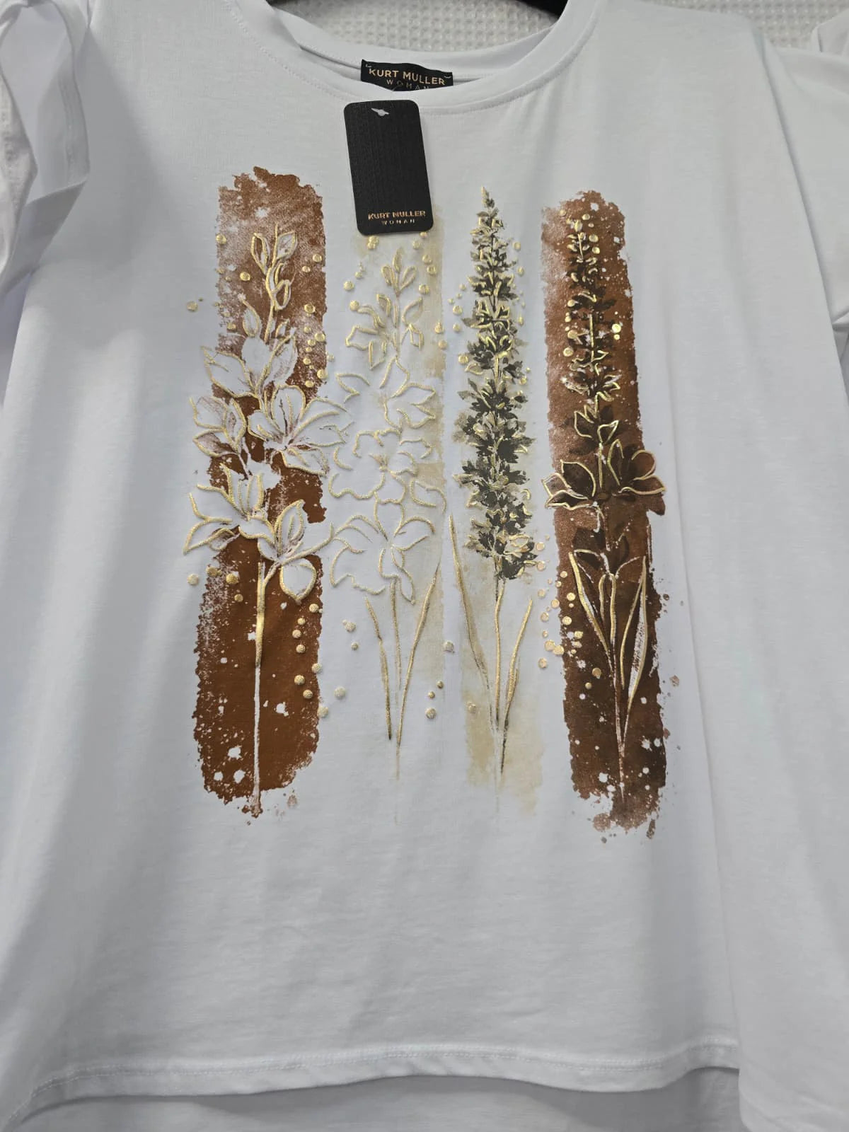 White t-shirt with floral design and tag on a white background