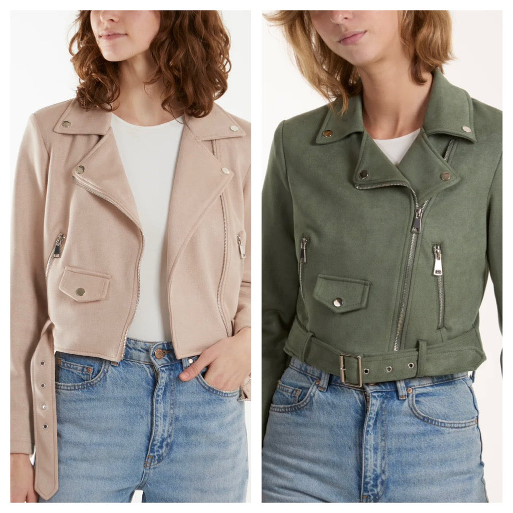 Two women wearing suede biker jackets in different colors, one in beige and the other in green, both with a front zip and belt detail.