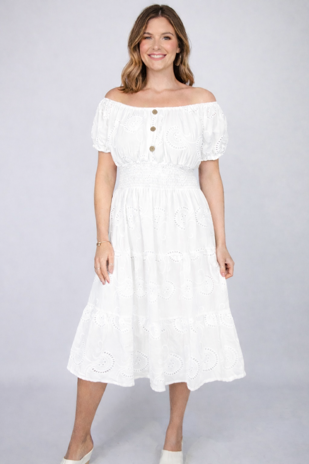 Woman wearing a white Broderie Anglaise Bardot Midi Dress dress on a gray background