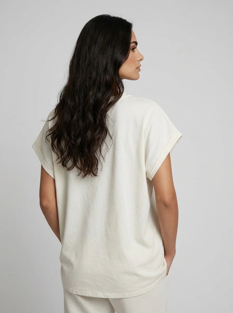 Back view of Woman wearing a light-colored t-shirt against a plain background
