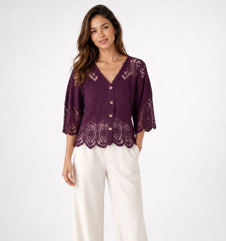 A woman modeling a wine lace cardigan with three-quarter sleeves and a button-front closure, paired with white wide-leg pants, against a plain white studio background.