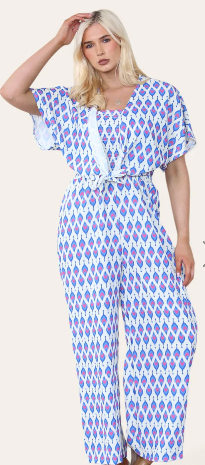 Woman Wearing Printed Geometric Jumpsuit With Bolero Jacket in Royal Blue.