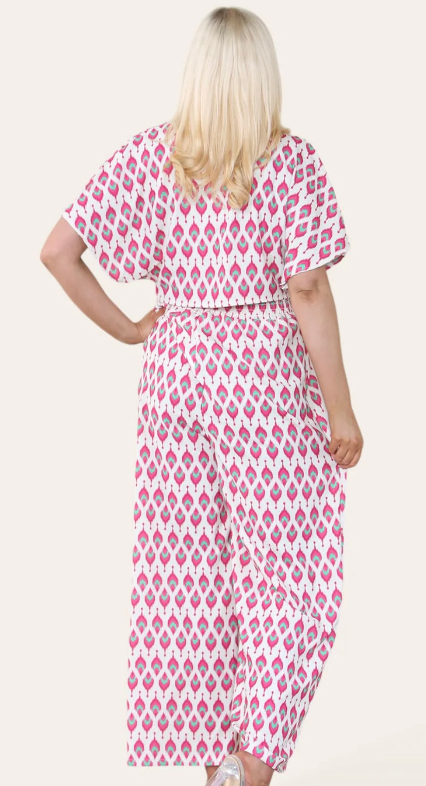 Woman Wearing Printed Geometric Jumpsuit With Bolero Jacket in Pink. Back View.