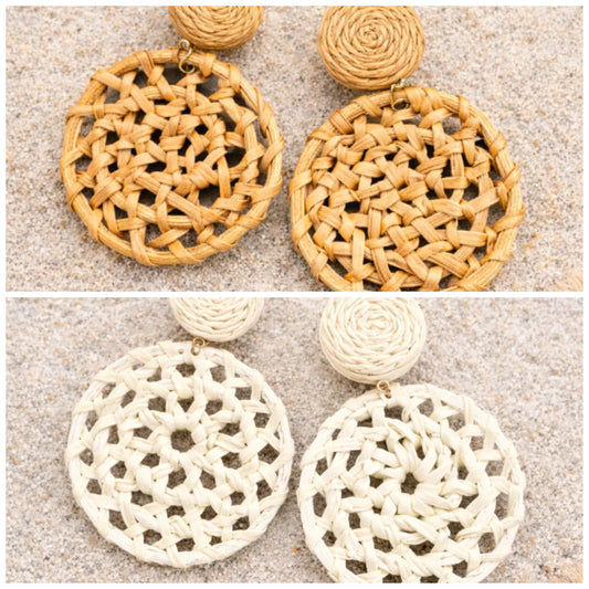 Woven round earrings in brown and white on a textured surface