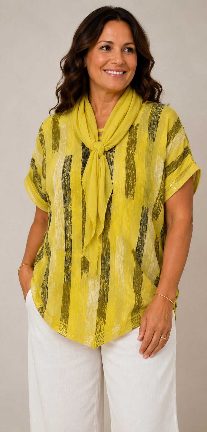 A woman modeling a yellow short-sleeve top with vertical black textured stripes and a matching yellow scarf, paired with white pants, against a plain light gray background.